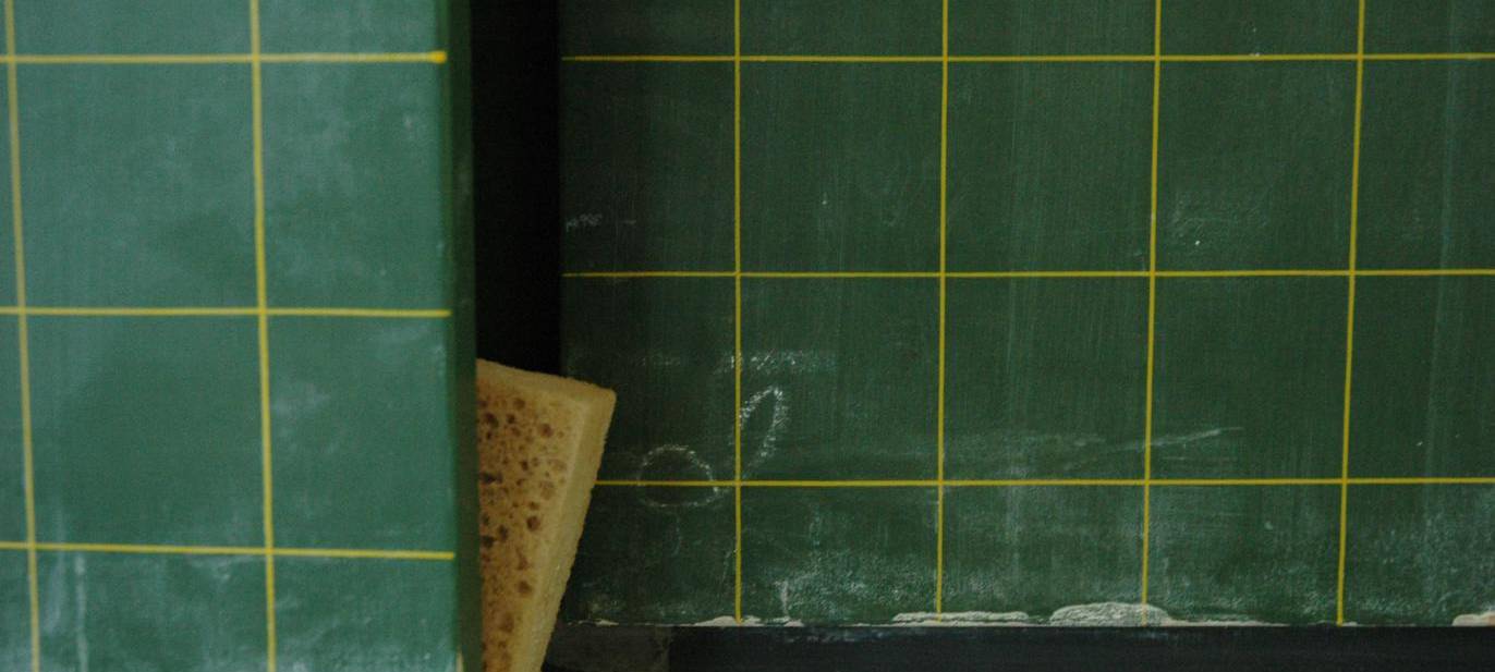 Tafel mit eingeklemmten Schwamm und Kreide