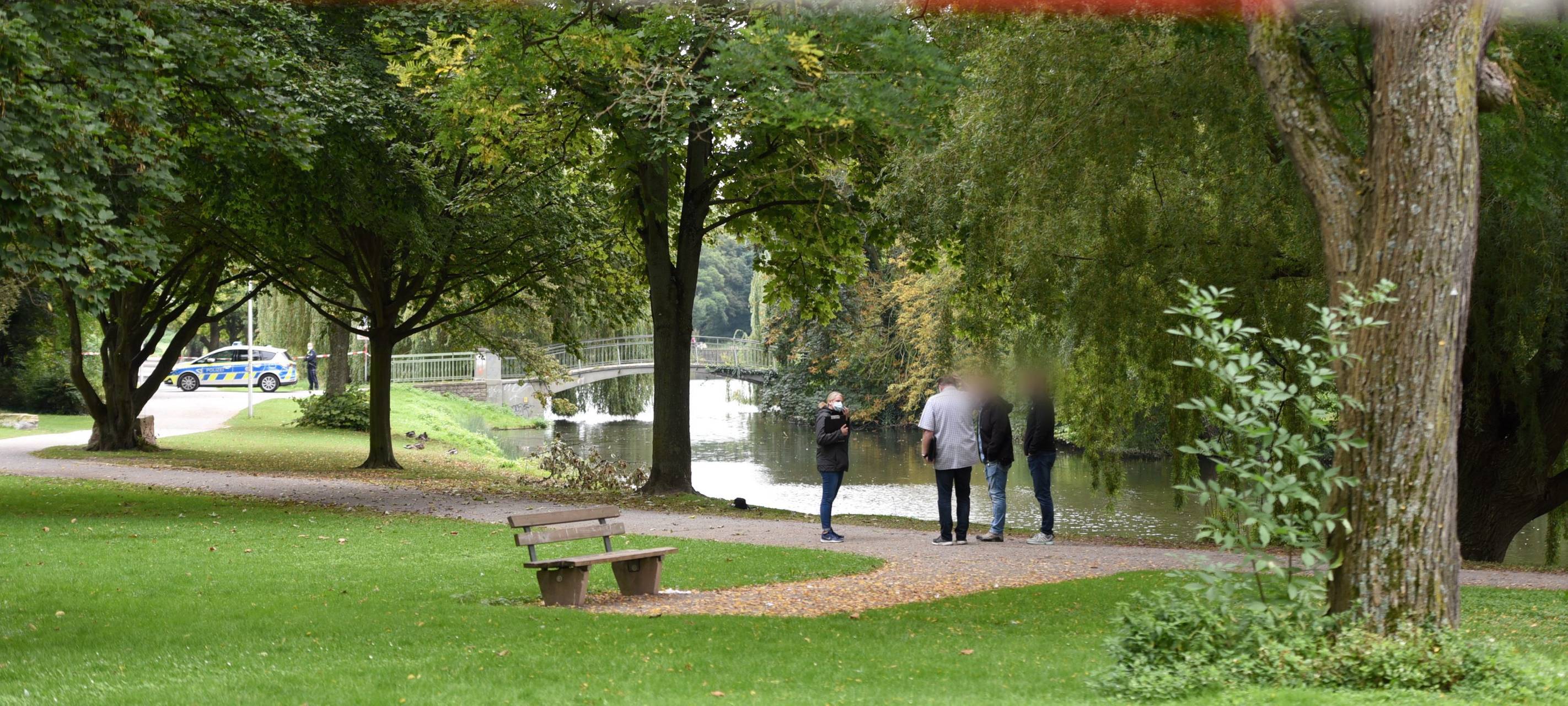 Einsatzkräfte der Polizei sichern den Tatort am OLG-See. Ein großer Teil des Parks hinter dem Oberlandesgericht in Hamm ist mit Flatterband abgesperrt.