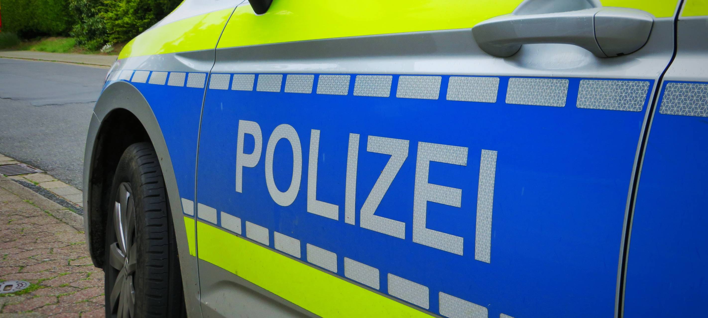 Ein Streifenwagen der Polizei. Er steht am Wegesrand.