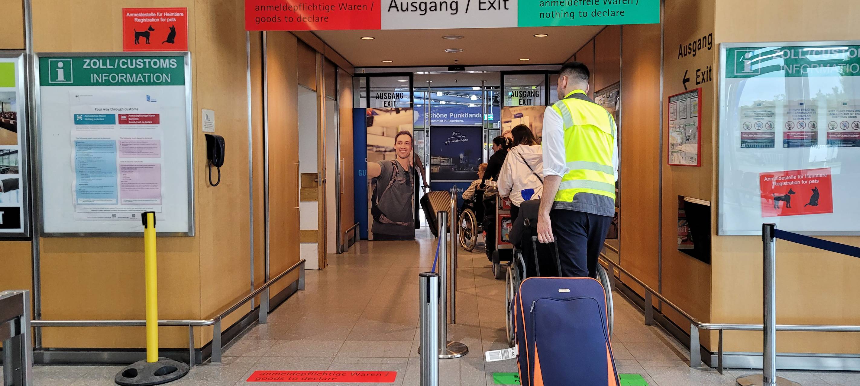 Reisende gehen am Flughafen Paderborn-Lippstadt durch die Zollkontrolle.