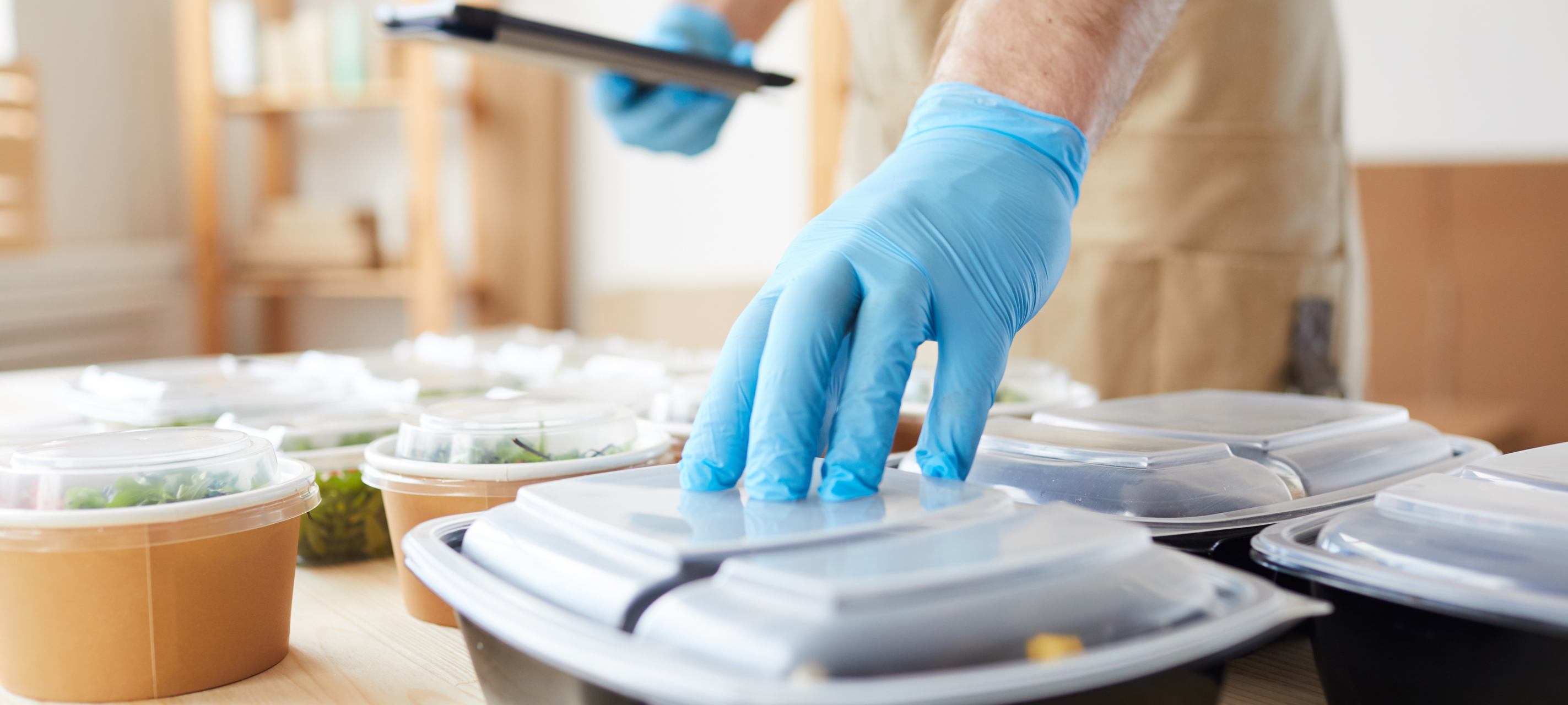 Ein Imbiss-Mitarbeiter verpackt eine Bestellung.